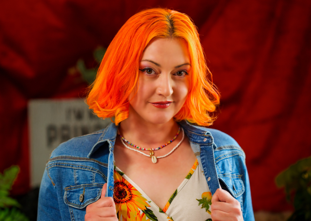 A headshot of musician Rebecca Dawn holding onto her jacket.